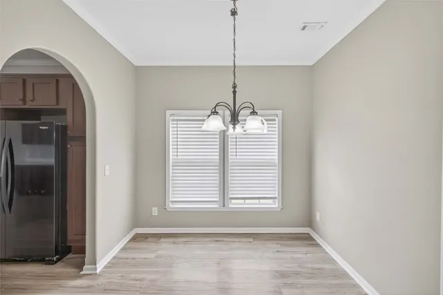 a view of empty room with window and hardwood floor