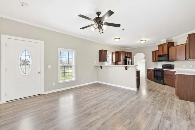 a view of an empty room with window and wooden floor