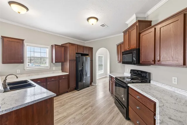 a kitchen with stainless steel appliances granite countertop a sink stove and refrigerator
