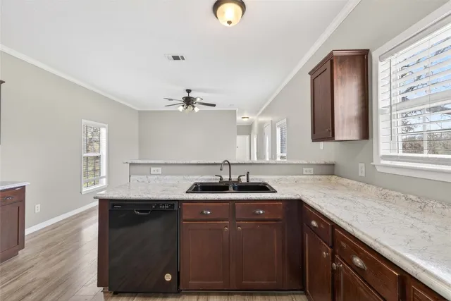 a kitchen with a granite countertop sink and a wooden floor