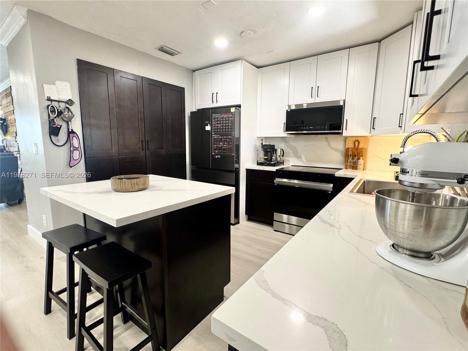 14849 Southwest 114th Court Miami, FL 33176 - Photo 2 of 23 a kitchen with stainless steel appliances granite countertop a sink a stove a refrigerator and a refrigerator