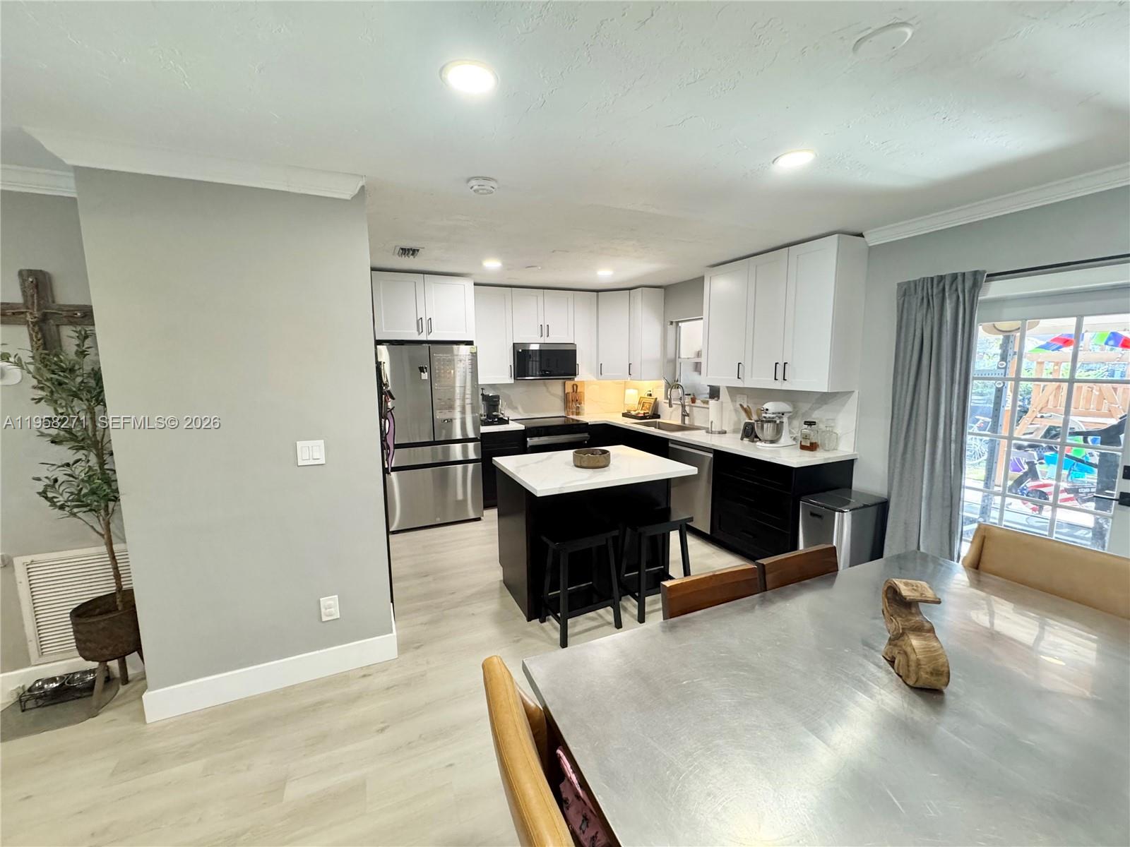 14849 Southwest 114th Court Miami, FL 33176 - Photo 5 of 23 a kitchen with a sink refrigerator and cabinets