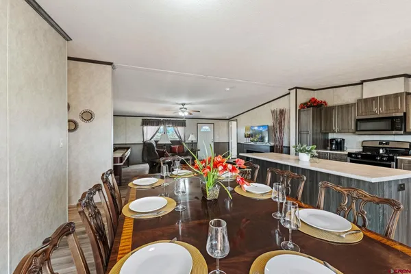a dining room with furniture a kitchen view and wooden floor