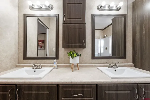 a bathroom with double sink and two mirror