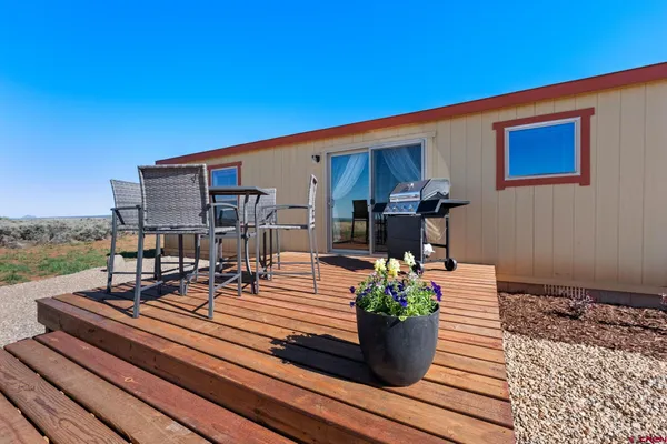 a view of a rooftop deck with couch and chairs