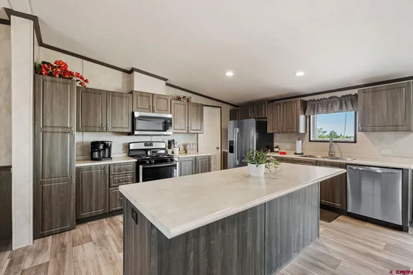 a kitchen with kitchen island a sink appliances and cabinets