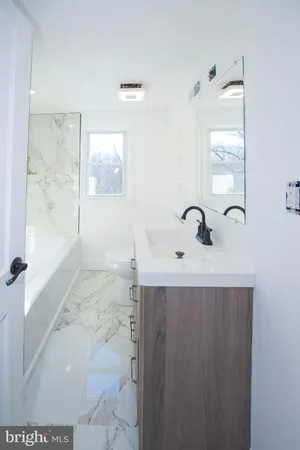 a bathroom with a sink a toilet and mirror