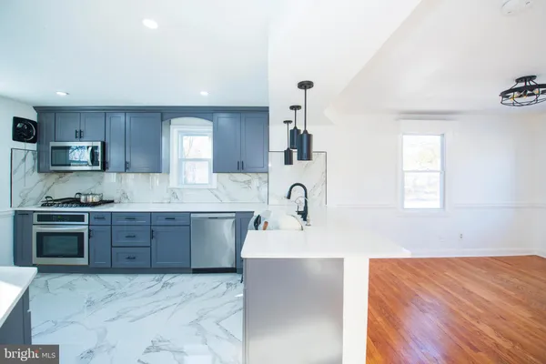 a large kitchen with stainless steel appliances kitchen island granite countertop a sink and cabinets