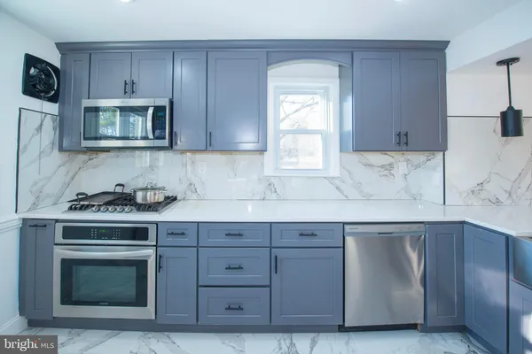 a kitchen with cabinets appliances and a sink