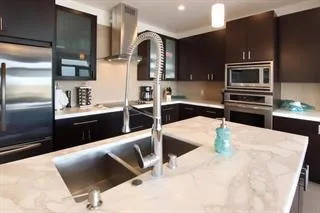 a kitchen with stainless steel appliances kitchen island granite countertop a sink and cabinets