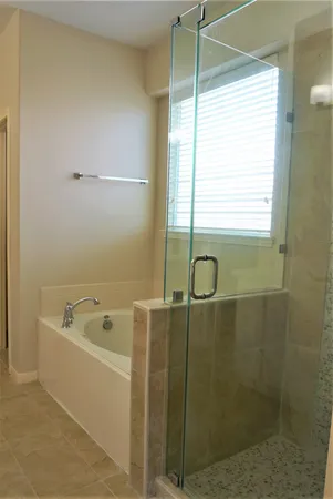 a bathroom with a tub a window and a shower