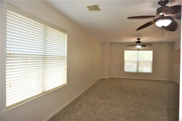 en empty room with windows and fan