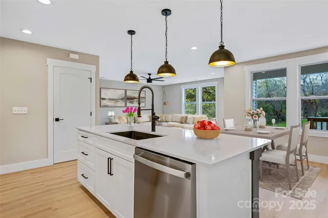 a kitchen with kitchen island a counter space a sink and a chandelier