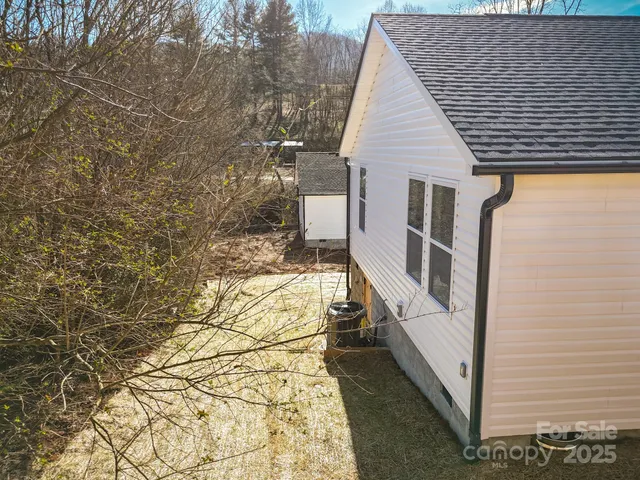 a view of a house with backyard and wooden fence