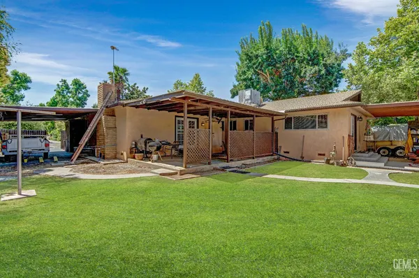 a view of a house with backyard and sitting area