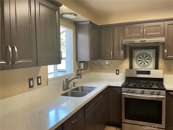 a kitchen with stainless steel appliances granite countertop a sink stove and cabinets