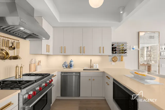 a kitchen with stainless steel appliances a sink a stove a refrigerator and cabinets