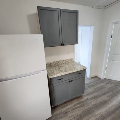 a view of a kitchen with a sink and wooden floor