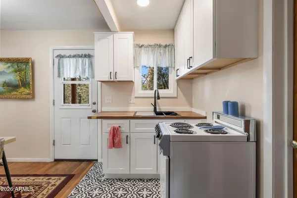a kitchen with stainless steel appliances wooden floor and a refrigerator