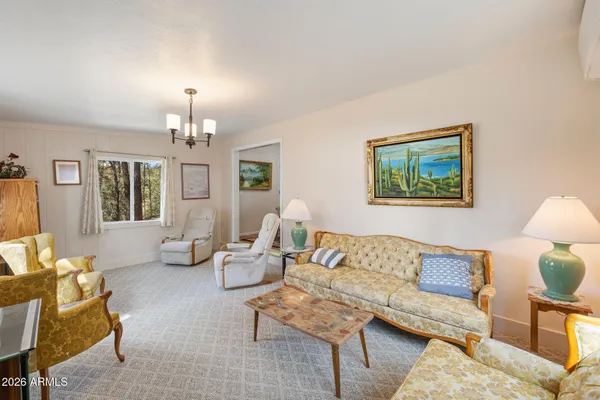 a living room with furniture a flat screen tv and large window