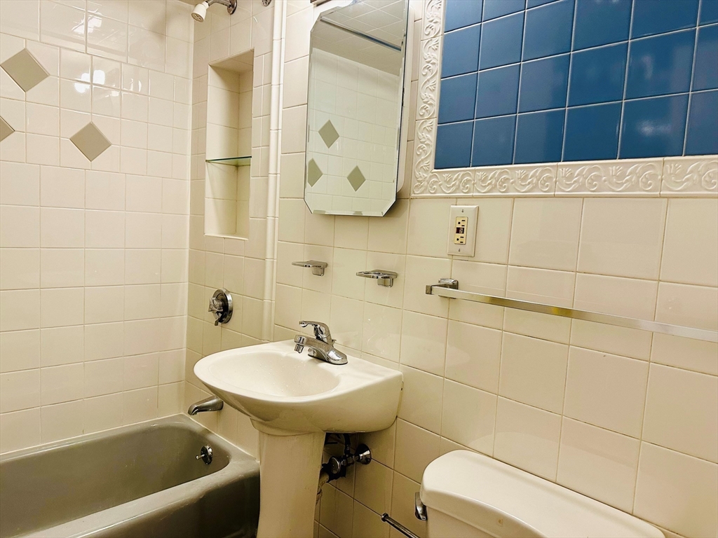 1105 Lexington Street, Unit 84 Waltham, MA 02452 - Photo 4 of 5 a bathroom with a sink a toilet and shower