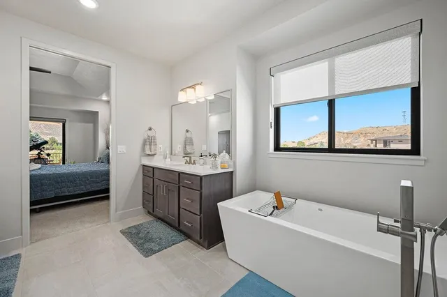 a bathroom with a tub a sink and a mirror