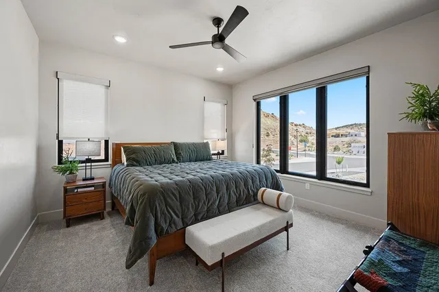 a bedroom with a bed lamps and a large mirror