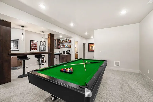 a room with pool table and windows