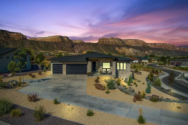 a front view of a house with a yard and mountain view