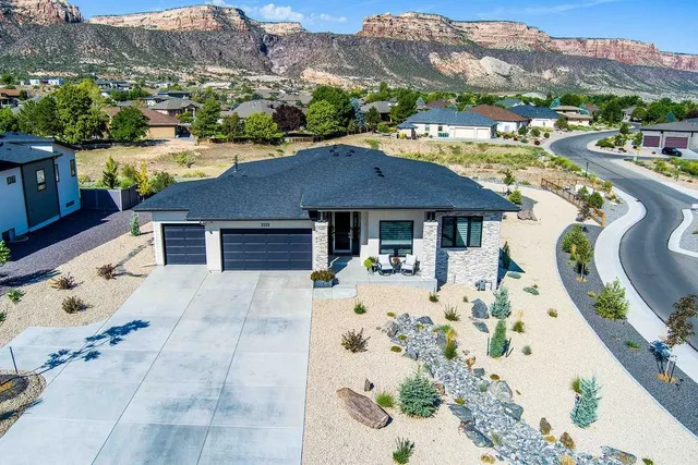 a front view of a house with a yard swimming pool and mountain view in back