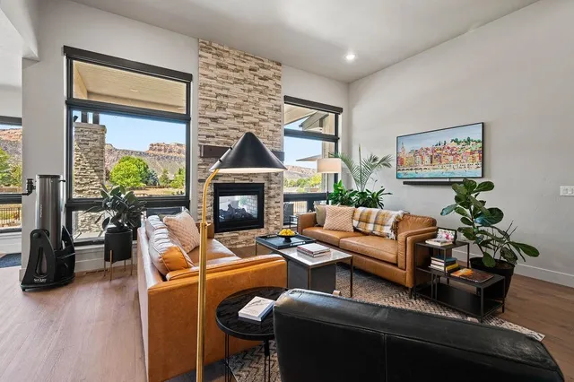 a living room with furniture a fireplace and a floor to ceiling window