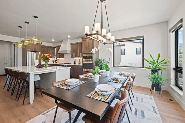 a view of a dining room and livingroom with furniture wooden floor a chandelier