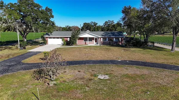 a view of a big house with a big yard and large tree
