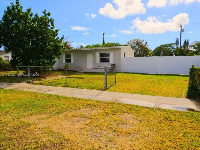 a view of a swimming pool with a lawn chairs under an umbrella