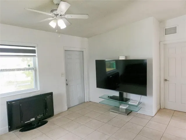 a living room with flat screen tv and gym equipment