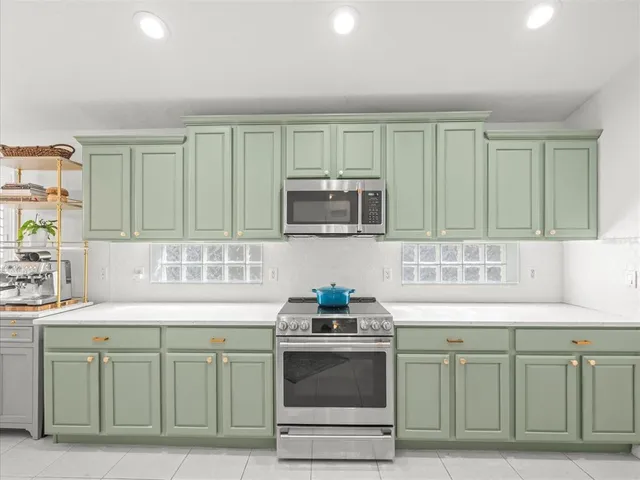 a kitchen with kitchen island a stove a microwave a dining table and chairs