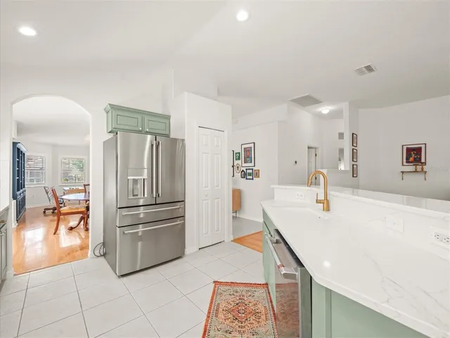 a dining room filled chandelier and kitchen view