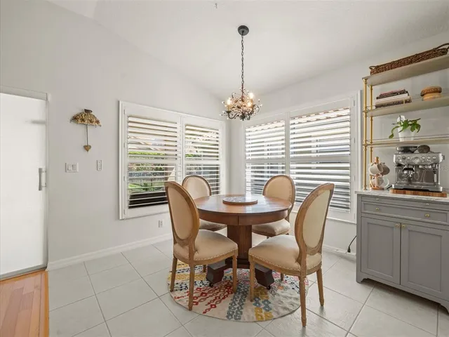 a living room with furniture a chandelier and a dining table