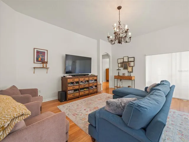 a bedroom with a bed and dresser with wooden floor