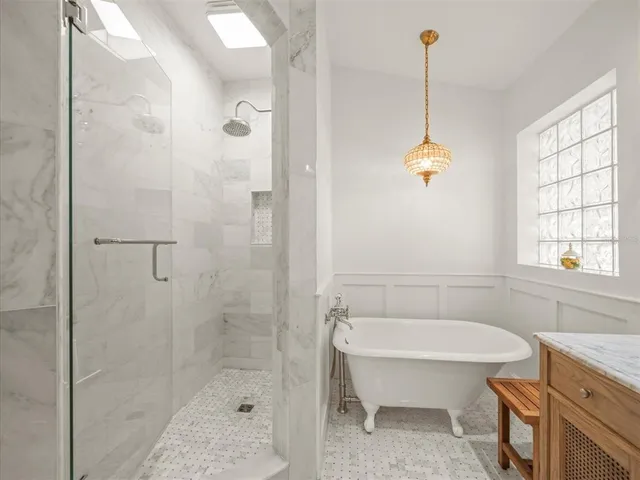 a bedroom with a large bed and a chandelier