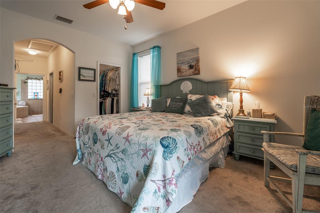 15969 Southwest 14th Avenue Road Ocala, FL 34473 - Photo 18 of 46 a bedroom with a bed and a chandelier
