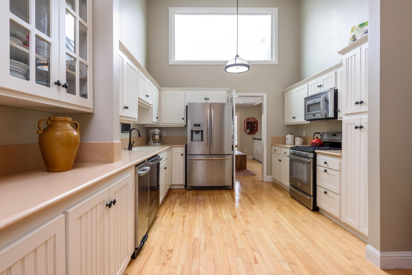 29 Pinehurst Lane Half Moon Bay, CA 94019 - Photo 5 of 17 a kitchen with stainless steel appliances a refrigerator a stove top oven a sink dishwasher and white cabinets with wooden floor