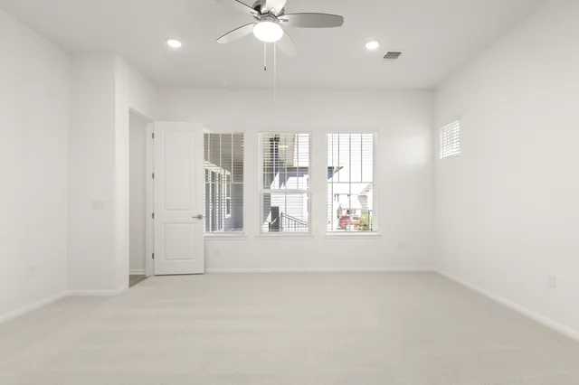 an empty room with closet and a chandelier fan