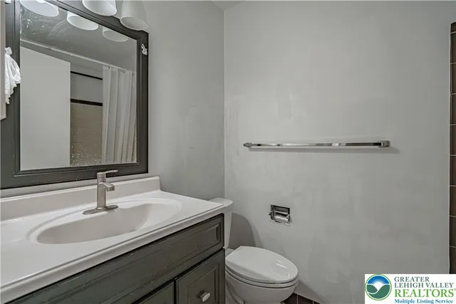 a bathroom with a sink vanity mirror and toilet