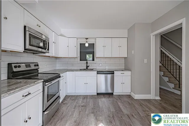 a kitchen with stainless steel appliances granite countertop a stove and a microwave