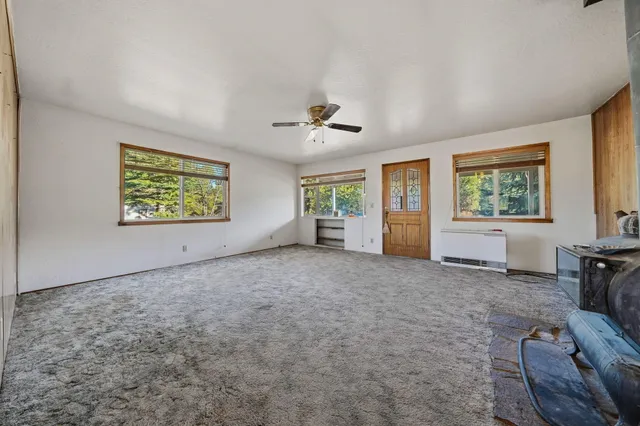 a view of a livingroom with furniture a ceiling fan and wooden floor