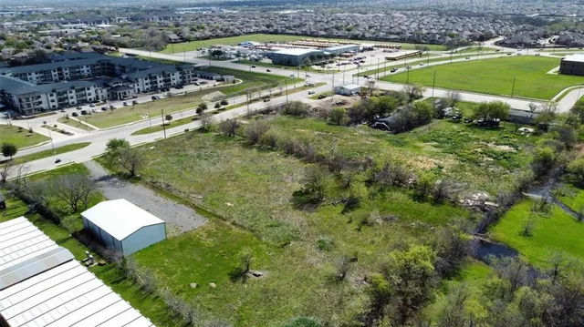 a view of a dry yard with wooden fence