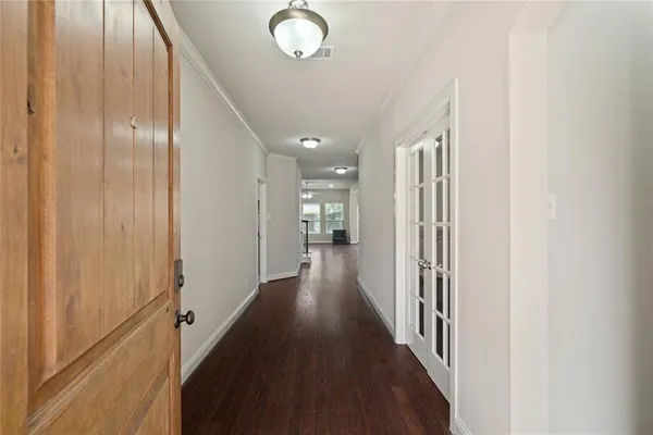 a view of an empty room with wooden floor and a fireplace