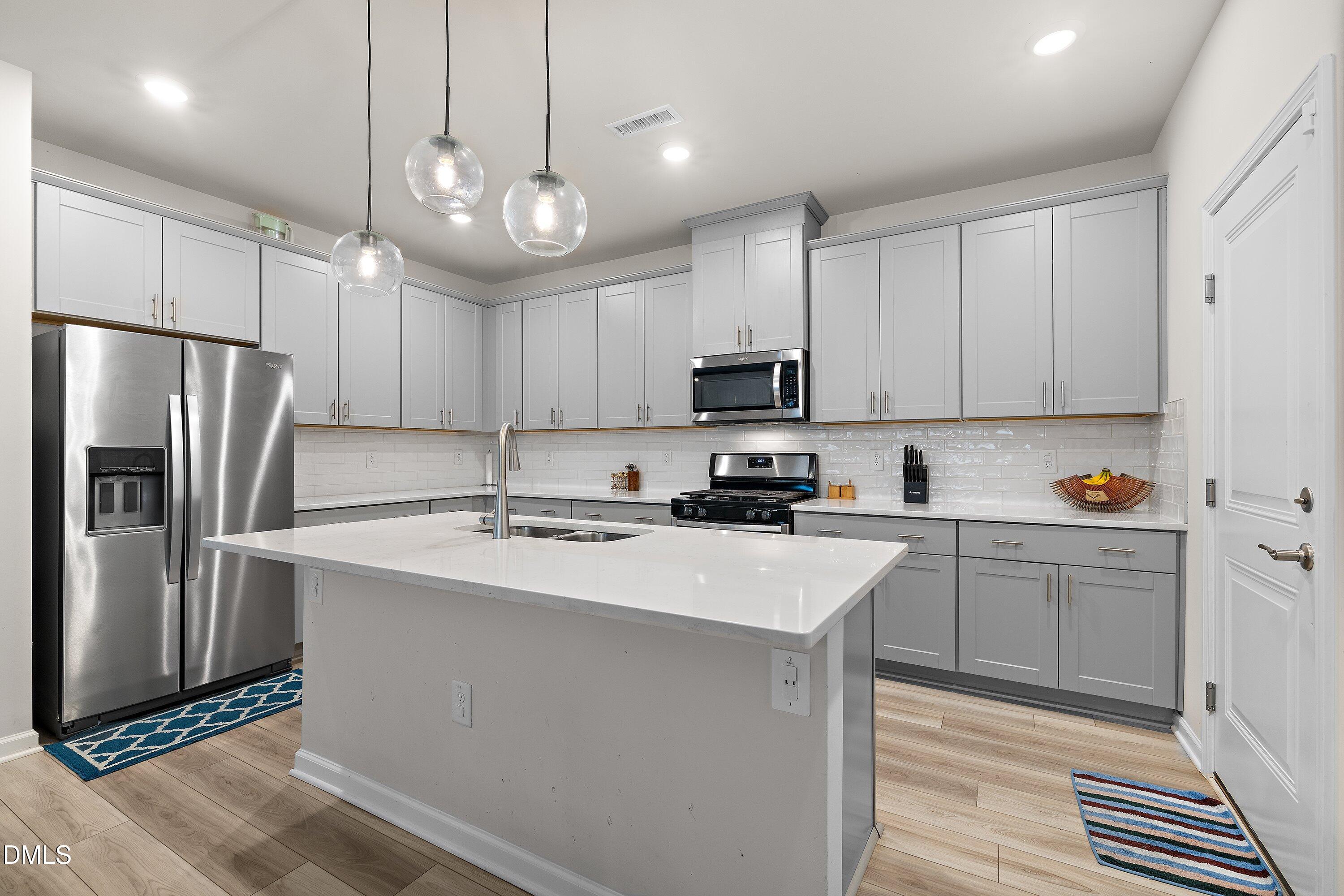 154 Anise Tree Way Clayton, NC 27527 - Photo 15 of 43 a kitchen with kitchen island granite countertop a sink stainless steel appliances and cabinets