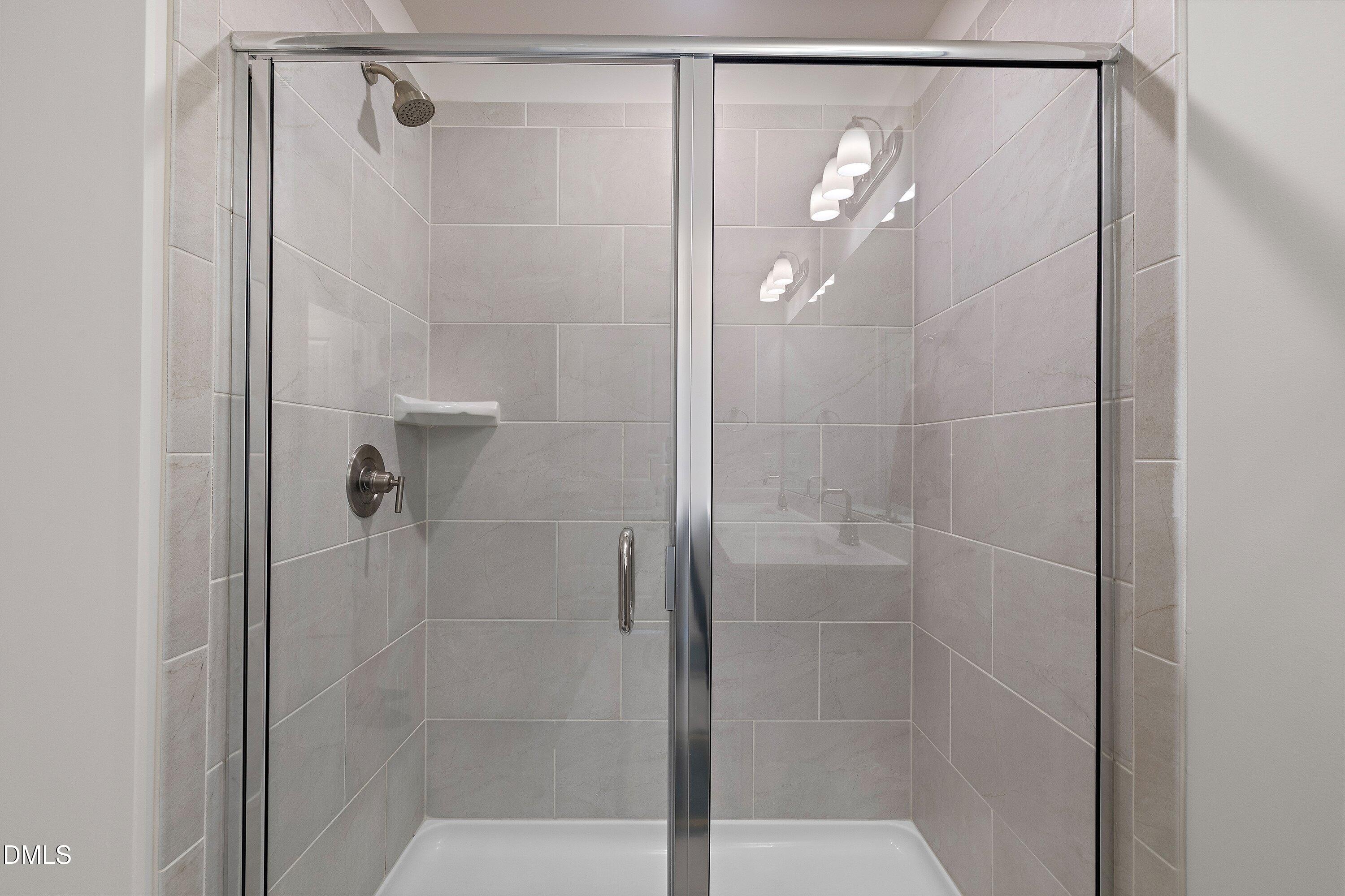 154 Anise Tree Way Clayton, NC 27527 - Photo 28 of 43 a bathroom with a glass shower door
